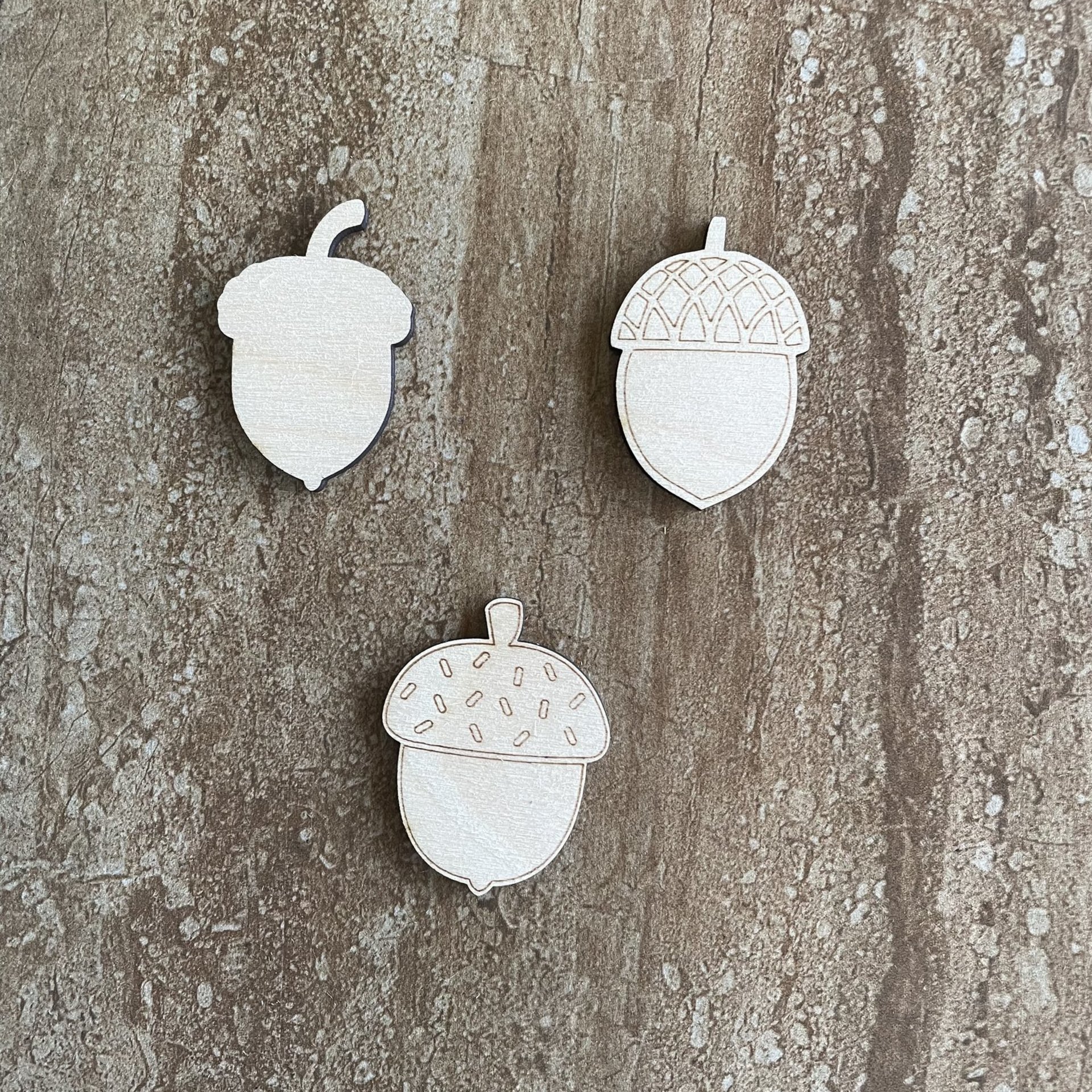 Handmade wood acorn cutouts in three DIY craft styles