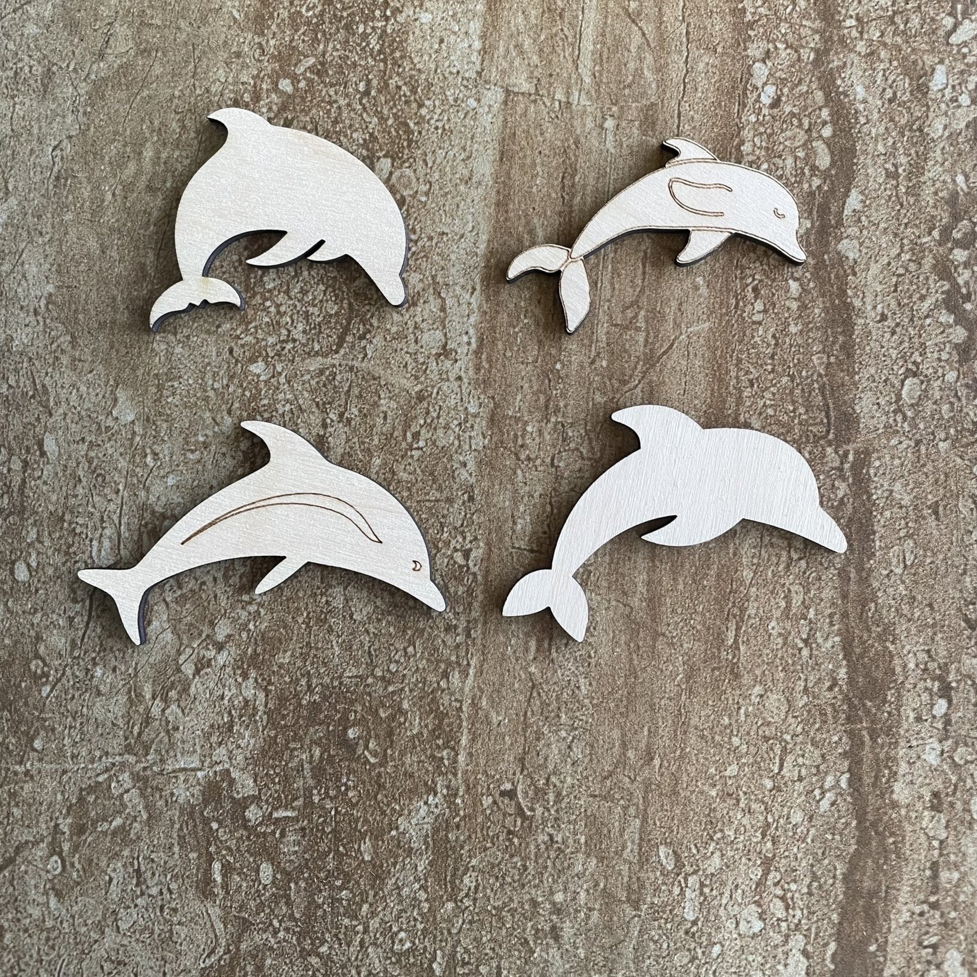 Handmade wood dolphin cutouts in four unique DIY craft styles