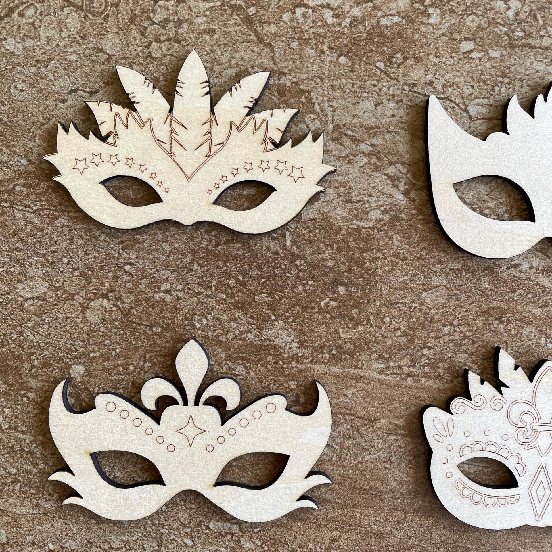 Handmade wooden DIY mardi gras mask cutout in four unique styles, ready for paint or decorating