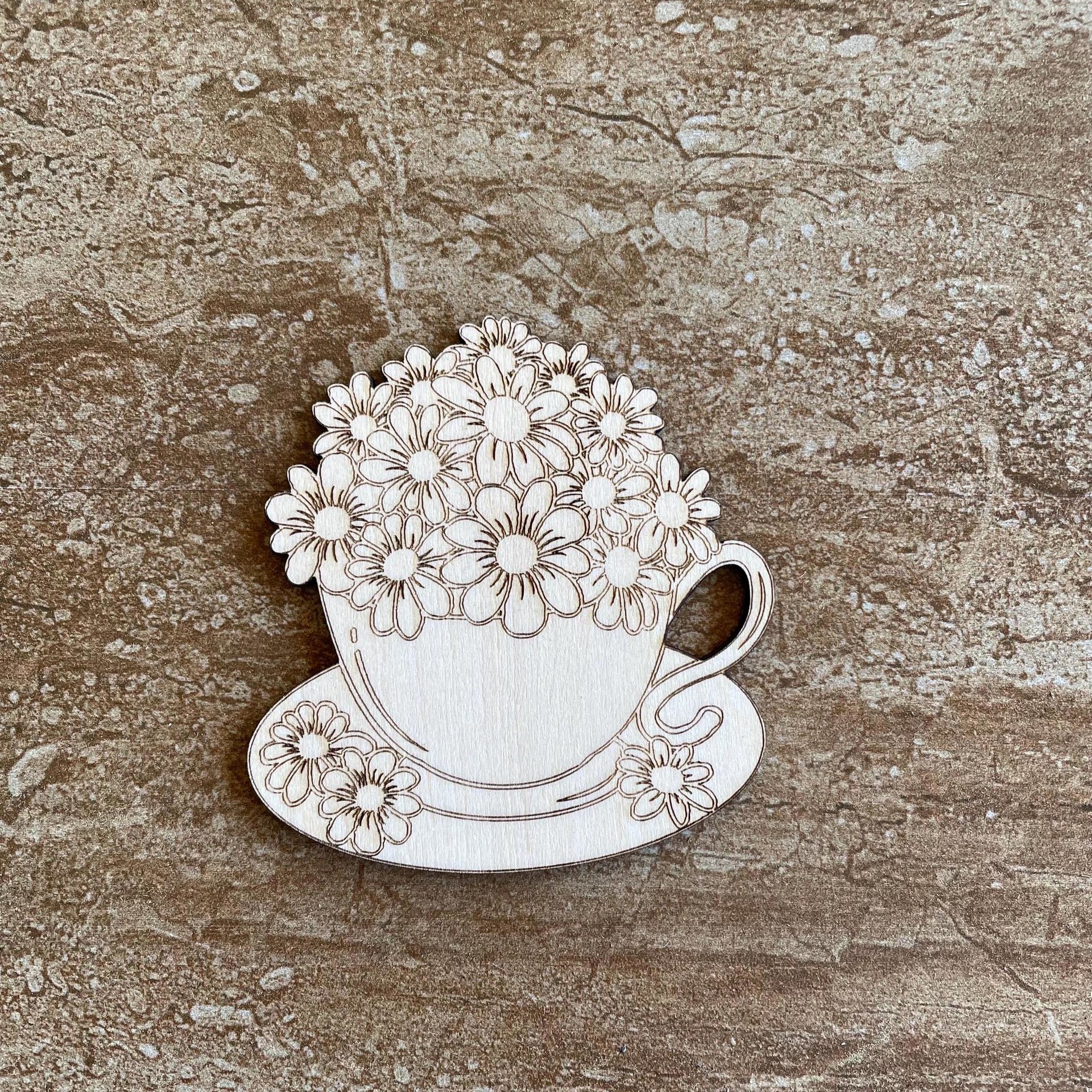 Handmade wooden DIY cutout of a coffee cup filled with flowers that are ready for paint or decorations