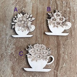 Handmade wooden DIY cutout of a coffee cup filled with flowers that are ready for paint or decorations