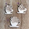 Handmade wooden DIY cutout of a coffee cup filled with flowers that are ready for paint or decorations